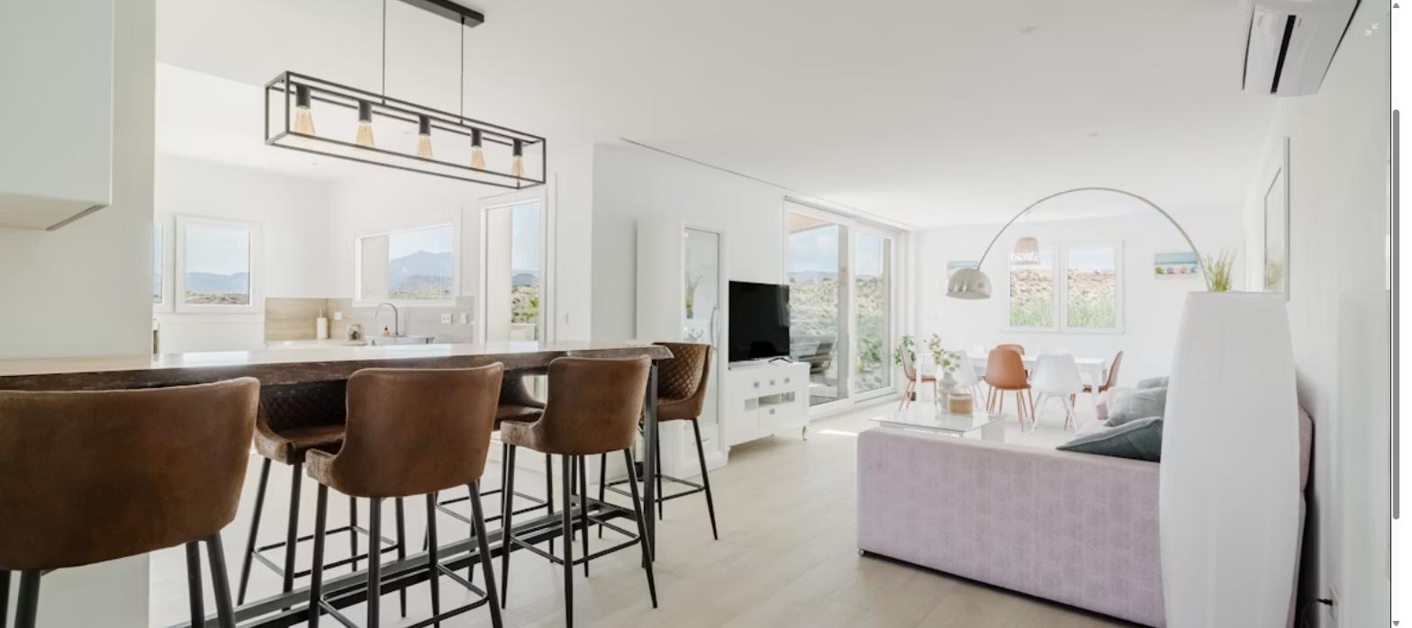 Salón moderno en apartamento de temporada Salón luminoso con cocina abierta y zona de estar